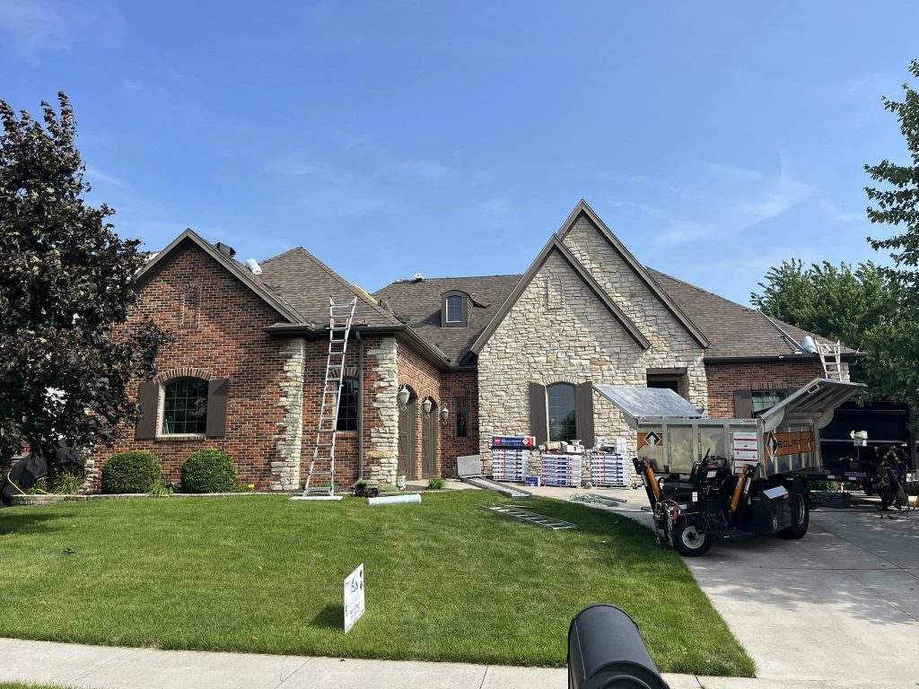 Roofing crew during the roof replacement process installing new shingles on a Central Illinois home
